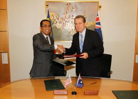 Malaysian Minister of Higher Education, Mohamed Khaled Nordin (left) exchanging documents with Minister for Tertiary Education, Senator Chris Evans after signing the MoU.